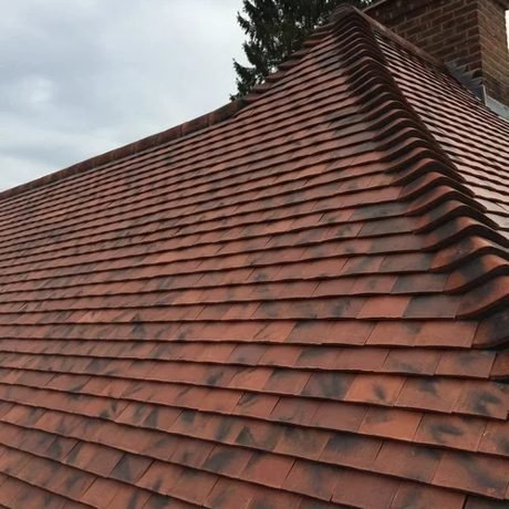 New clay tile roof with a hip and ridge, installed by Tresan Roofing in Surrey